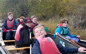 Children paddling canoes on the river