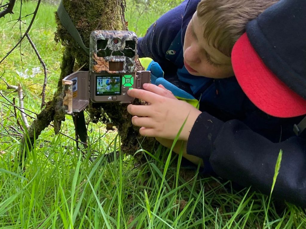 Two junior rangers setting up a camera trap